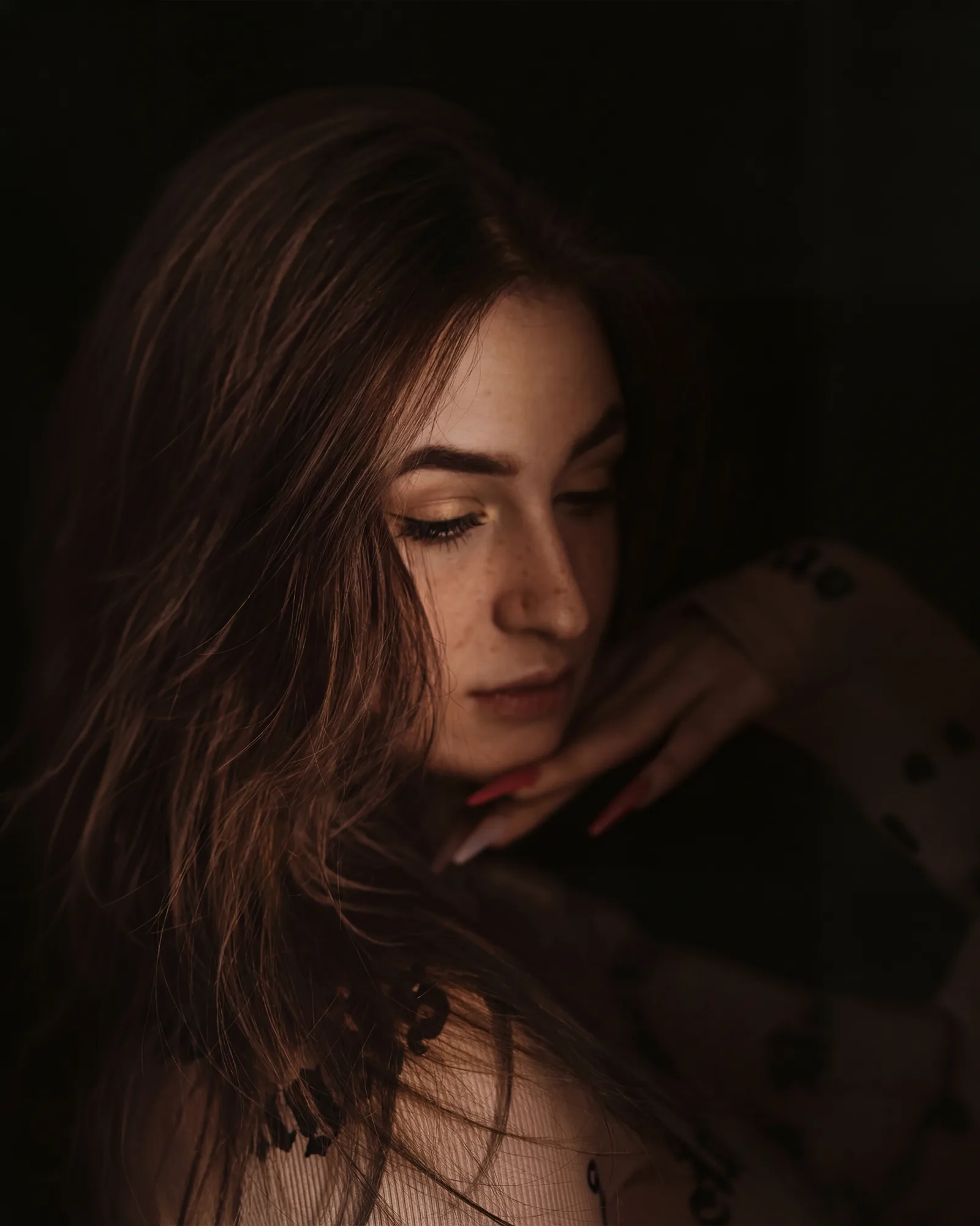Portret w ciepłym niskim świetle, spojrzenie w dół
