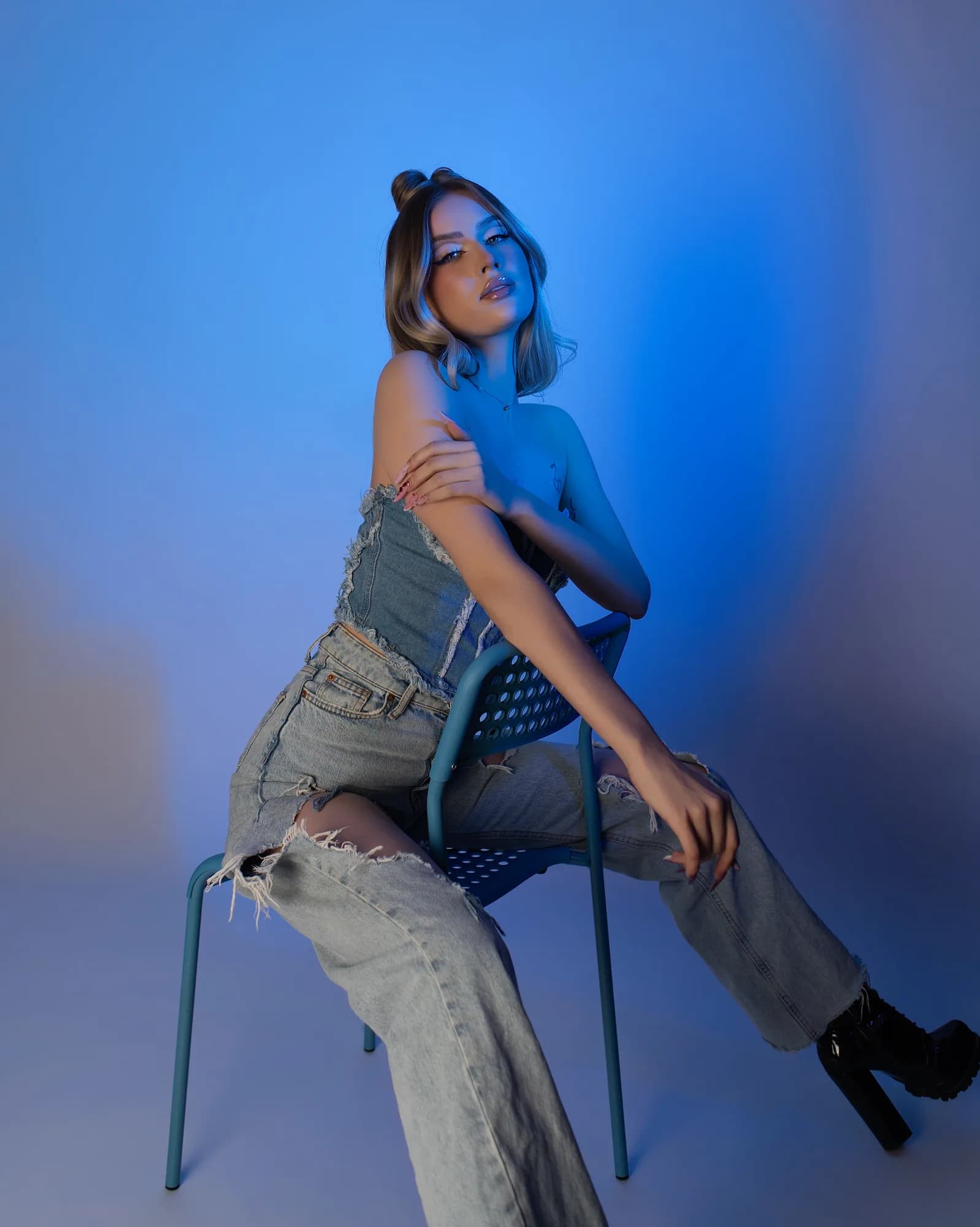 Sesja stylizowana - denim na krześle w niebieskim świetle
