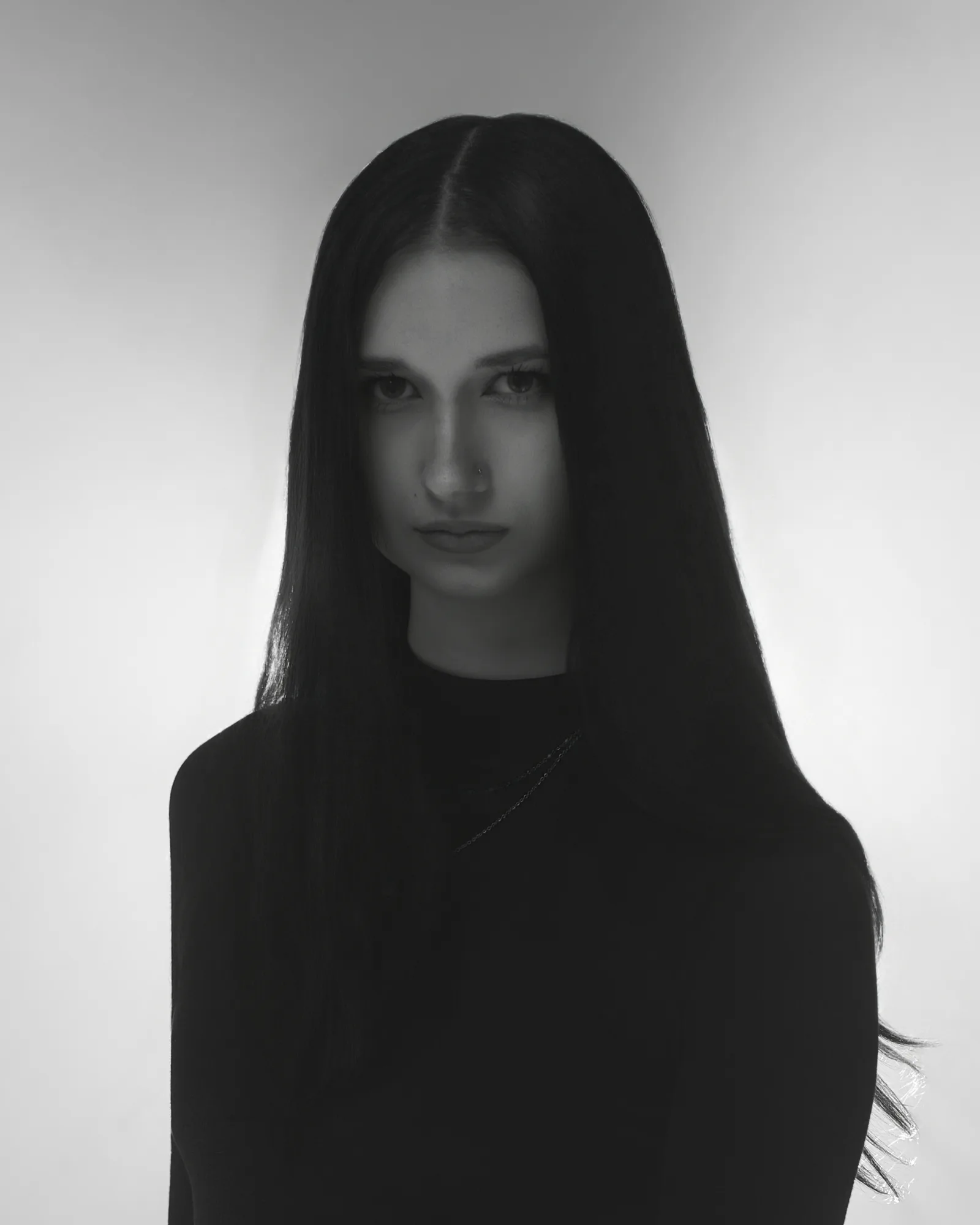 Czarno-biały portret z długimi włosami, spojrzenie wprost